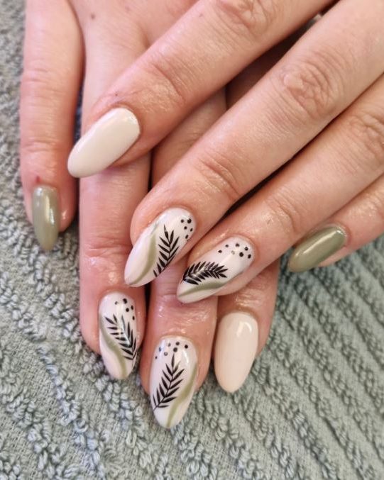 Ongles nude et kaki, deux ongles décorés de feuillage noir.